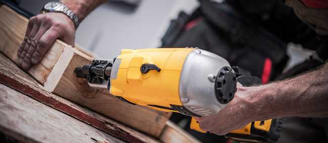 Man using nail gun on lumber